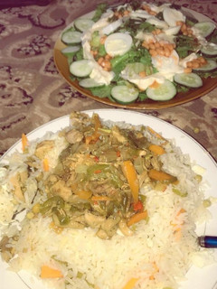 A picture of Chinese rice with chicken sauce and salad.
