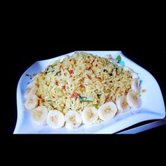 A picture of Jollof rice with banana.