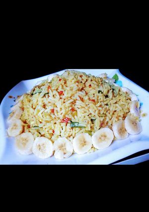 A picture of Jollof rice with banana.