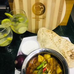 A picture of Keema Aloo w afghani naan, dahi and lemonade.