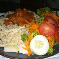 A picture of Macaroni with sauce and salad.