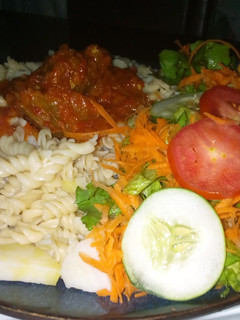 A picture of Macaroni with sauce and salad.