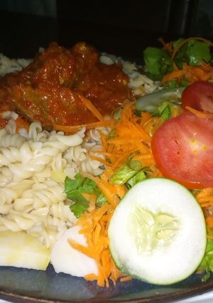 A picture of Macaroni with sauce and salad.