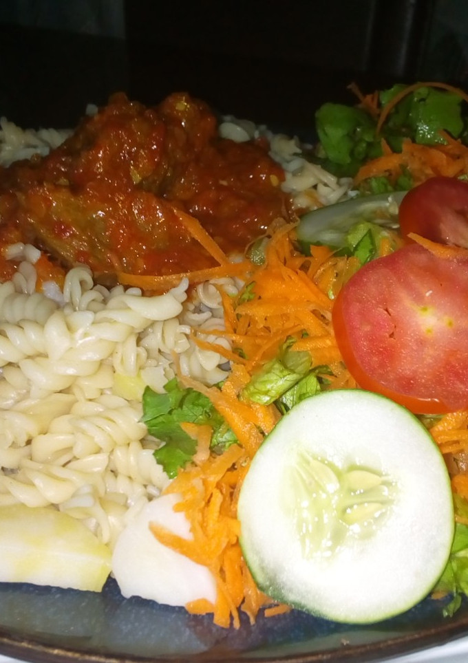 A picture of Macaroni with sauce and salad.