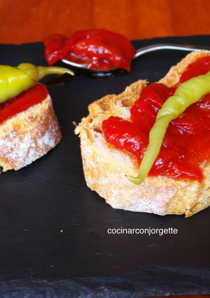 Una foto de Rebanadas de pan rústico con pimientos caramelizados y guindillas