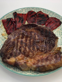 Una foto de Chuletón gallego madurado con pimientos de piquillo