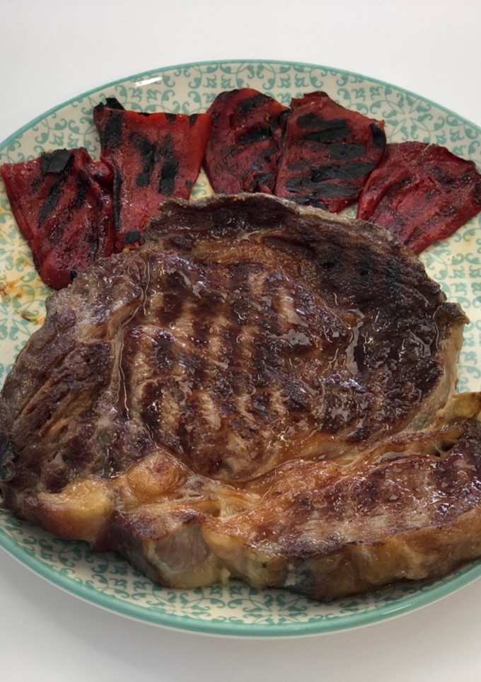 Una foto de Chuletón gallego madurado con pimientos de piquillo