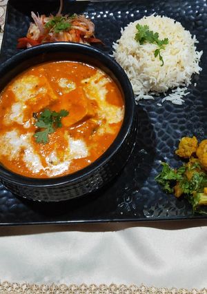 A picture of Handi paneer with boiled rice, aloo gobhi and salad.