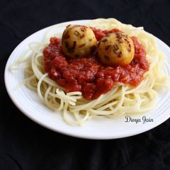 A picture of Spaghetti in Bolognese Sauce with Golden Paneer Balls.