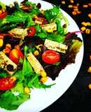 Ensalada Capriccio con tofu marinado, uvas pasas, maíz y cherrys