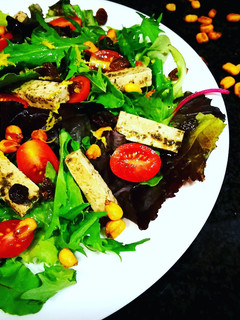 Una foto de Ensalada Capriccio con tofu marinado, uvas pasas, maíz y cherrys