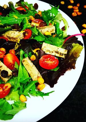 Una foto de Ensalada Capriccio con tofu marinado, uvas pasas, maíz y cherrys