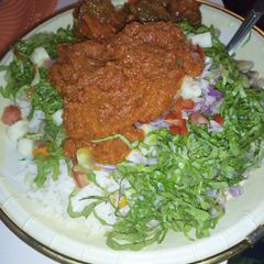 A picture of Rice and stew with salat.