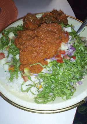 A picture of Rice and stew with salat.