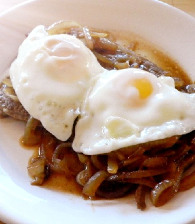 Una foto de Bifes con cebollas y huevos