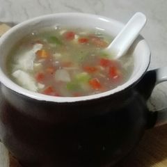 A picture of Hot and sour soup with cheesy bread sticks.