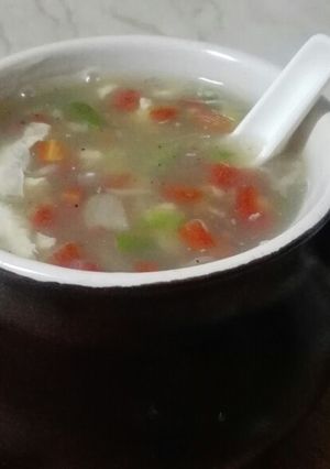A picture of Hot and sour soup with cheesy bread sticks.