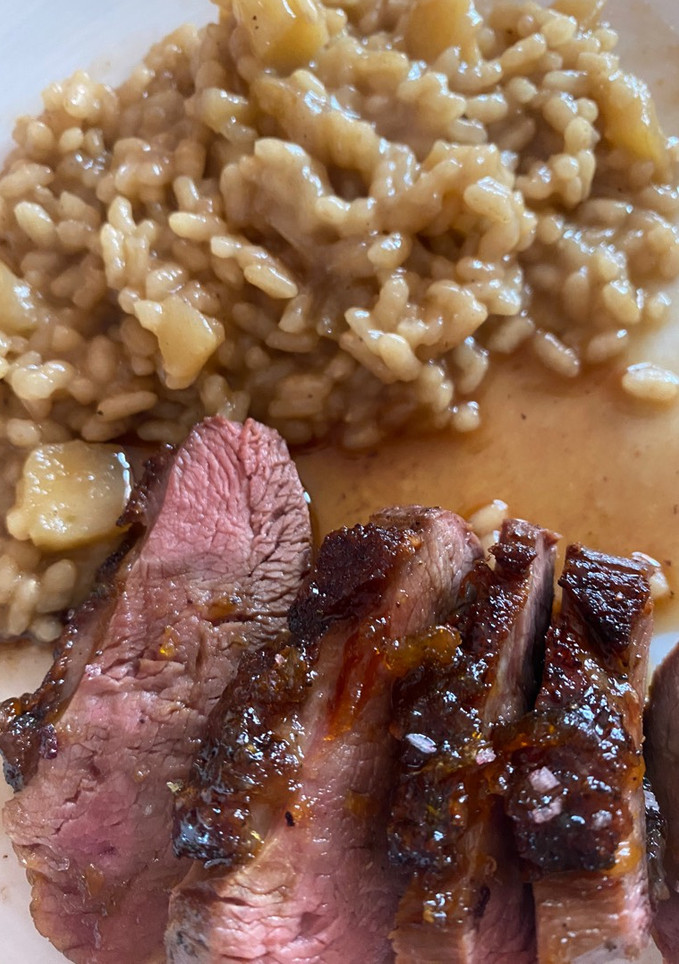 Una foto de Magret de pato con risotto de manzana y salsa de mandarina