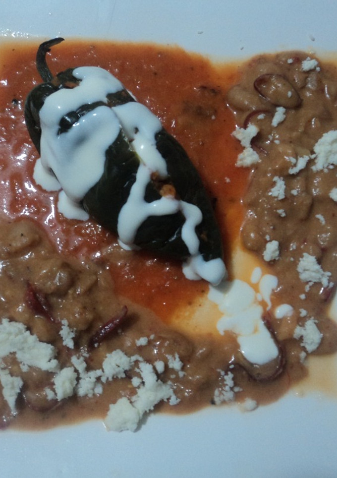 Una foto de Chile relleno de totopos entomatados y pollo, con frijoles con pelo de ángel de chile, las Correa