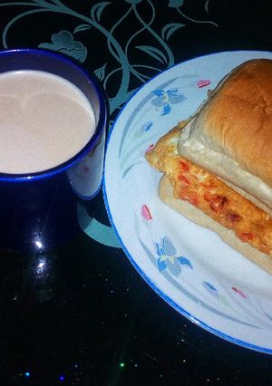 A picture of Egg sandwich and a cup of hot tea.