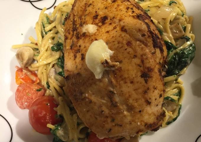 Stuffed chicken on a bed of creamy cheesy noodles