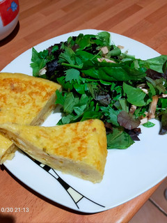 Una foto de Tortilla de patatas con cebolla con ensalada