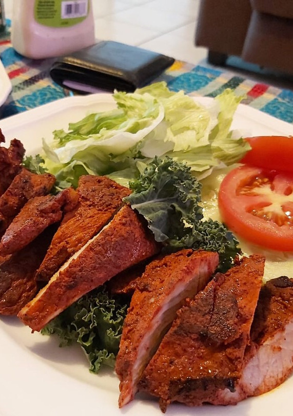 Una foto de Carne adobada con ensalada verde y roja