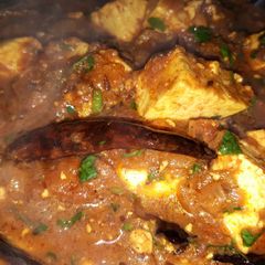 A picture of Paneer masala with Parantha and white butter.