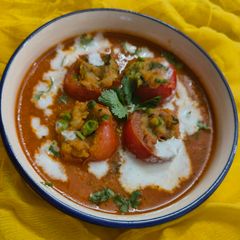 A picture of Stuffed Tomatoes in gravy.