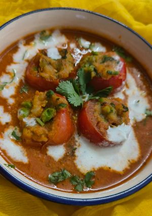 A picture of Stuffed Tomatoes in gravy.