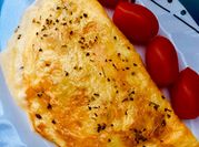 Una foto de omelette con tomates cherry y queso