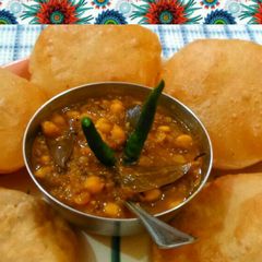 A picture of Chole puri / white peas with fried bread.