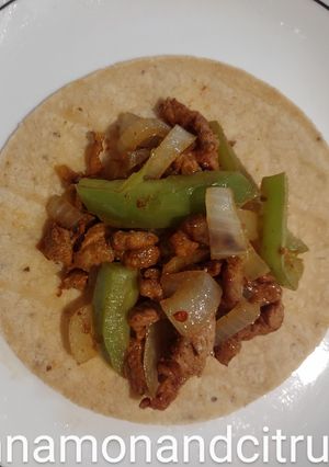 A picture of Pork Al pastor with sauteed onions and peppers.