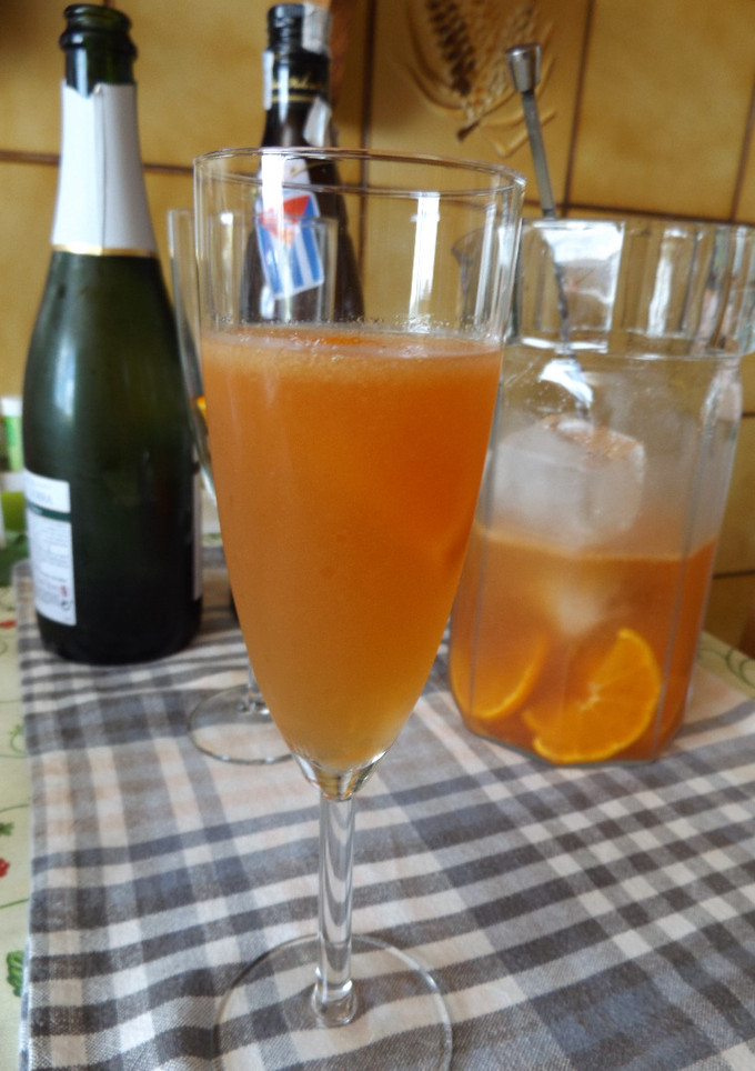 Una foto de Cóctel de mandarinas, cava y ron tostado