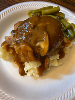 A picture of Simple Salisbury steaks over mashed potatoes.