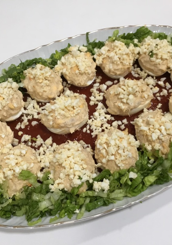Una foto de Huevos rellenos con base de tomate frito casero