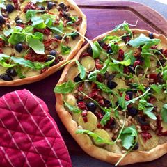 A picture of Roasted garlic, potato & arugula pizza.