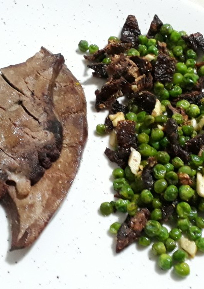 Una foto de Hígado de cerdo con salteado de guisantes, dientes de ajo tomate