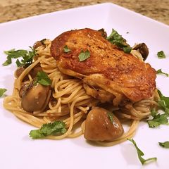 A picture of Crispy chicken thigh with angel hair, mushroom and garlic butter cilantro sauce.