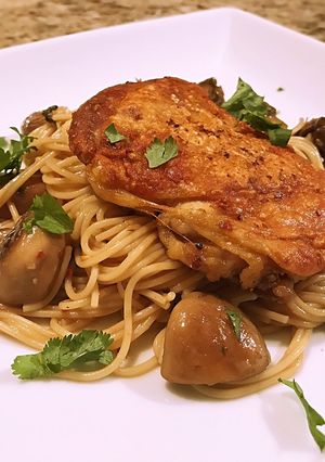 A picture of Crispy chicken thigh with angel hair, mushroom and garlic butter cilantro sauce.