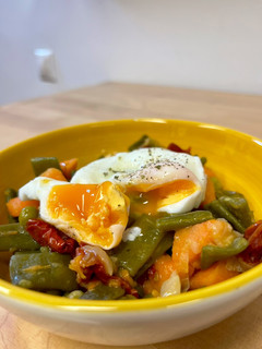 Una foto de Verduras con tomates secos y huevo poche
