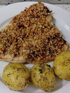 Una foto de Lubina al horno con costra de nueces y patatas salteadas con eneldo