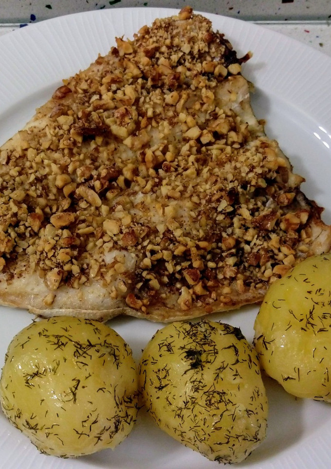 Una foto de Lubina al horno con costra de nueces y patatas salteadas con eneldo