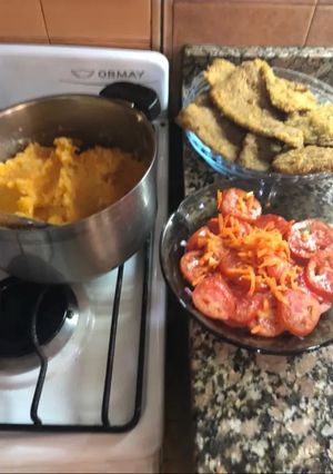 Una foto de Milanesa con puré mixto y tomates
