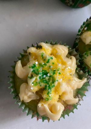 A picture of Vanilla cupcakes with vanilla frosting and sugar sprinkle.