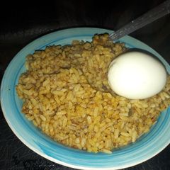 A picture of Palm oil rice with boiled egg.