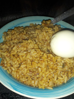 A picture of Palm oil rice with boiled egg.