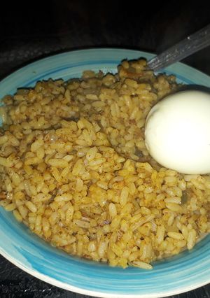 A picture of Palm oil rice with boiled egg.