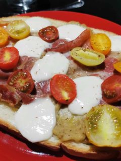 Une photo de Bruschetta caviar d'aubergines, tomates cerises, jambon cru et mozzarella