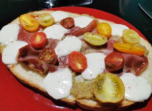 Une photo de Bruschetta caviar d'aubergines, tomates cerises, jambon cru et mozzarella